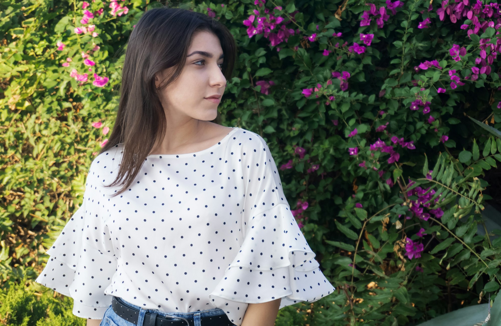 Young girl in profile against the background of a hedge